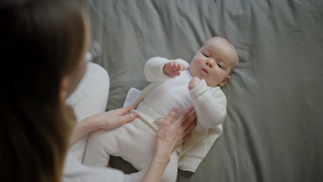 美丽的母亲和她的孩子。年轻美丽的女人看着她的小女儿。小女孩在妈妈怀里笑视频下载