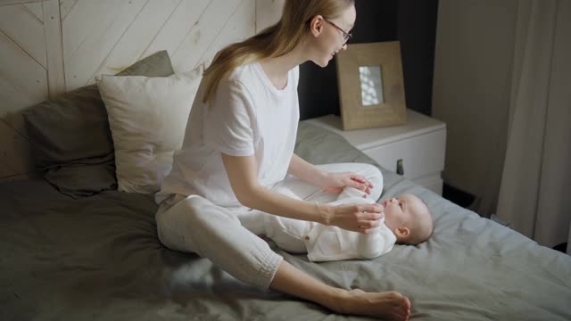 快乐的女人看着她的孩子笑了。漂亮的宝宝朝妈妈笑。母亲和她自己的孩子视频下载