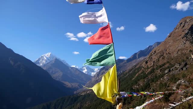 阳光明媚的日子里，尼泊尔昆布地区的夏尔巴人村庄纳姆切巴扎(Namche Bazar)在强风中飘扬着五颜六色的佛教经幡。视频素材