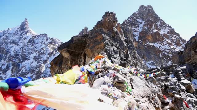 在尼泊尔喜马拉雅山脉中，珠穆朗玛峰地区的莲若拉山口(Renjo La Pass)顶上，五颜六色的佛教经幡在强风中飘扬。视频素材