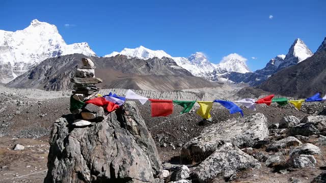 彩色的佛教经幡在强风中和平地飘扬在莲若拉山口，喜马拉雅山，尼泊尔，以冰雪覆盖的山脉为背景。视频素材