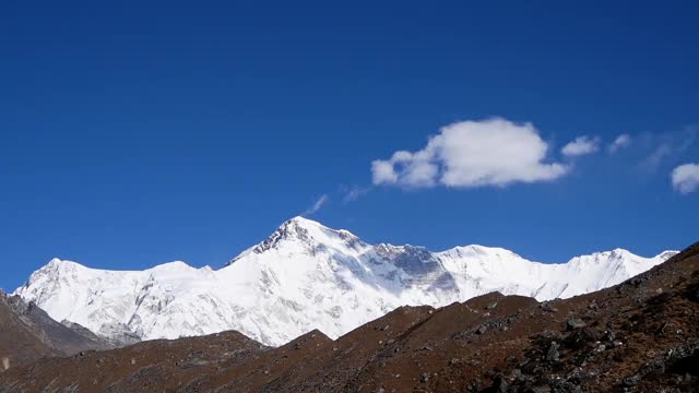 在尼泊尔昆布的Gokyo山谷，高耸的雪山Cho Oyu(峰顶8188米)上方的蓝色天空中升起的云朵。视频素材