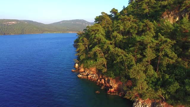 美丽的航拍绿岛在美丽的蓝色的海与群山包围的中央。自然的天堂。无人机拍摄的视频素材