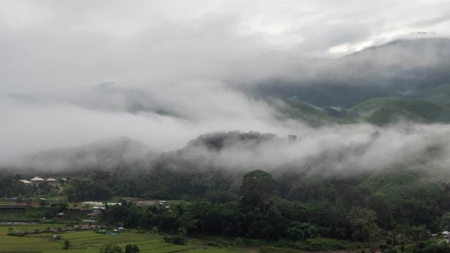 时光流逝的山谷，群山环抱，覆盖着浓厚的地面雾和薄雾高峰，美妙的早晨日出自然景观视频素材