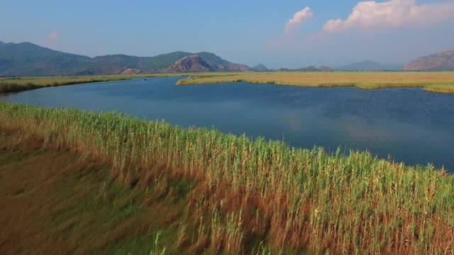 美丽的鸟瞰图芦苇在蓝色的水。山所包围了。Iztuzu。视频素材