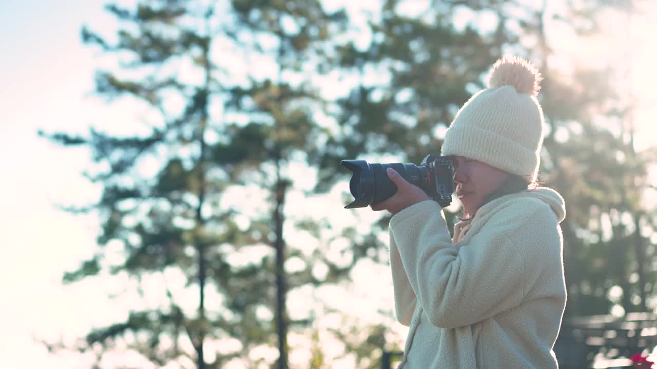 女摄影师用数码相机在冬季高峰岩石旅行时拍照视频素材