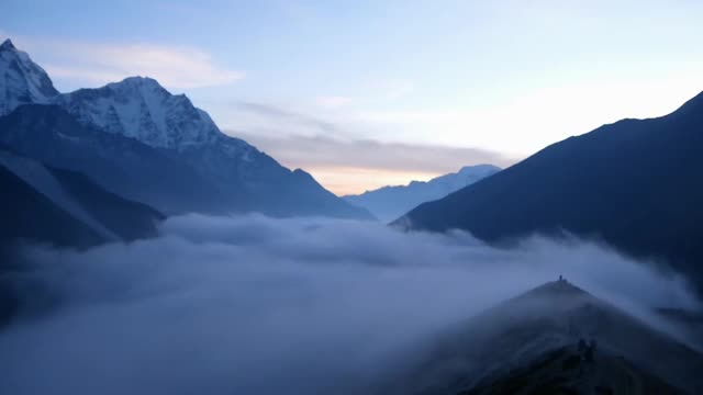 在时间的推移中，美丽的山谷在定伯切附近的全景，昆布，尼泊尔在喜马拉雅山与雄伟的雪山后日落和云移动回山谷。视频素材