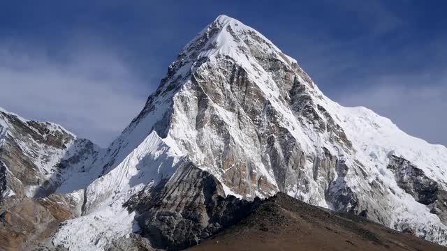 雄伟的雪山普莫里(顶峰:7161米)与卡拉帕特尔峰下面崎岖的喜马拉雅山与云通过缓慢观看从Lobuche，尼泊尔。视频素材