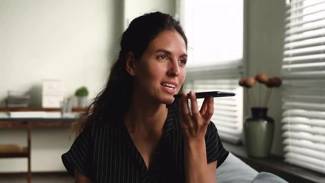 一名女子坐在屋里用手机和朋友聊天视频素材