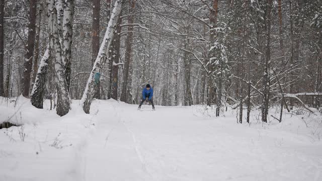 体育生活方式。一个男人在冬季森林里越野滑雪。准备视频素材