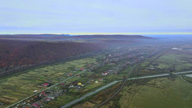 从高处鸟瞰美丽的乡村村庄，有房子和街道在犁地，草地视频素材