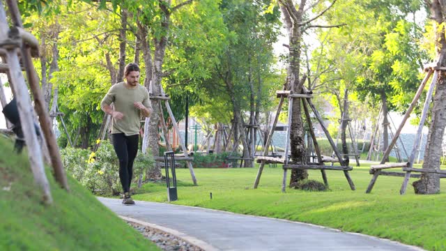 一个白人早上在村里的健康花园的公园里跑步。慢跑积极的生活方式概念。视频素材