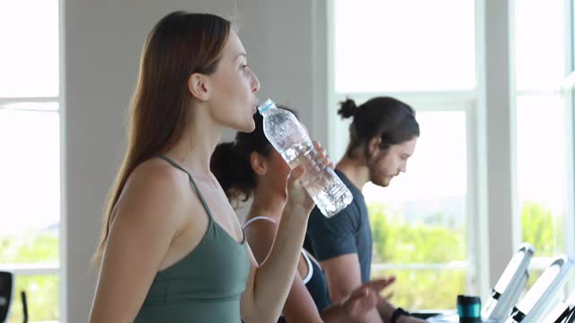 迷人的运动女性在健身房里跑步机上。视频素材