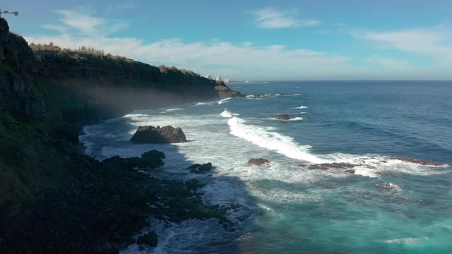 鸟瞰图海浪打破在海滩附近的黑色岩石。海浪对危险的石头鸟瞰图。视频素材