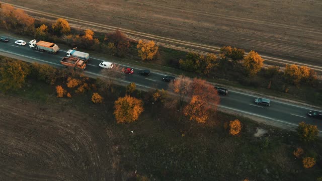 在秋天的夕阳下，汽车在高速公路上行驶。视频素材