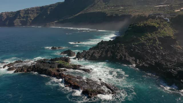 鸟瞰图海浪打破在海滩附近的黑色岩石。海浪对危险的石头鸟瞰图。视频素材