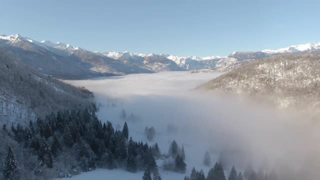 无人机:在壮观的雪山下，浓雾笼罩着山谷。视频素材