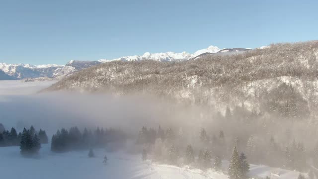 AERIAL:在阳光明媚的日子里，鸟瞰田园诗般的雪山风景。视频素材