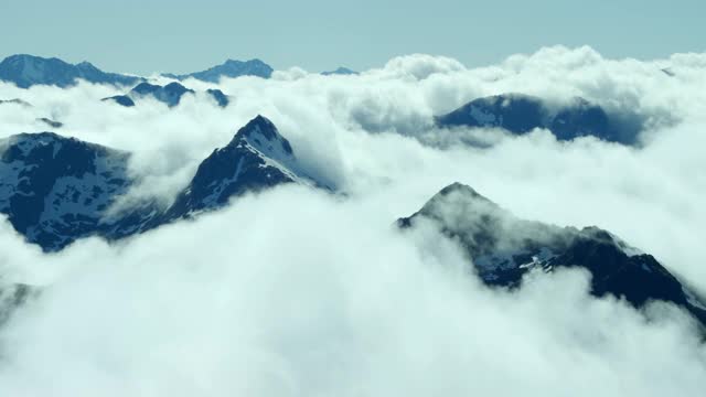 空中跟踪拍摄的一个近的山脉山峰通过高海拔白云视频素材