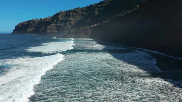 鸟瞰图海浪打破在海滩附近的黑色岩石。海浪对危险的石头鸟瞰图。视频素材