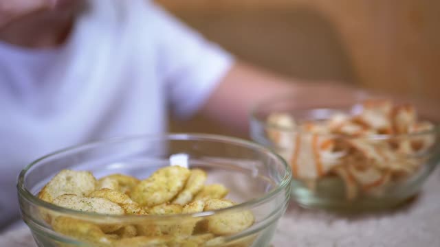 小孩的手从盘子里拿薯条，饼干。吃有害的零食视频素材