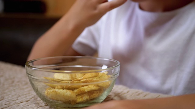 男孩的手从盘子里拿饼干。食用有害的零食。快餐视频素材