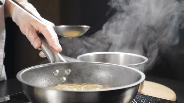 鱼汤从勺子里倒出来。传统意大利菜和食谱，慢镜头。意大利海鲜餐馆。在炉子上做意大利调味饭。全高清视频素材