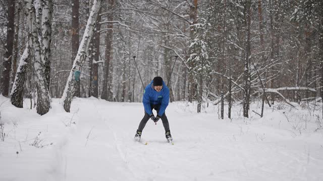 体育生活方式。一个男人在冬季森林里越野滑雪视频素材