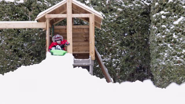 小男孩在冬天的户外雪地上滑行视频素材