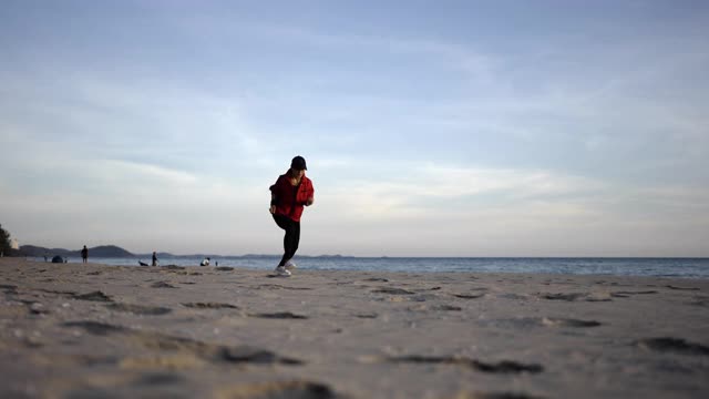 运动女子慢跑，在沙滩上跑步。视频素材