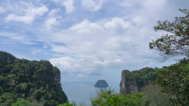 小岛在美丽的巨大的岩石山中间。蓝天白云飘过山头。晴天多云的天空。b - roll间隔拍摄的镜头。去泰国南部的海滩旅游。视频素材