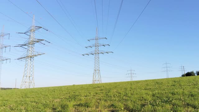 架空在架空电线下，高耸的输电塔映衬着蓝天视频素材