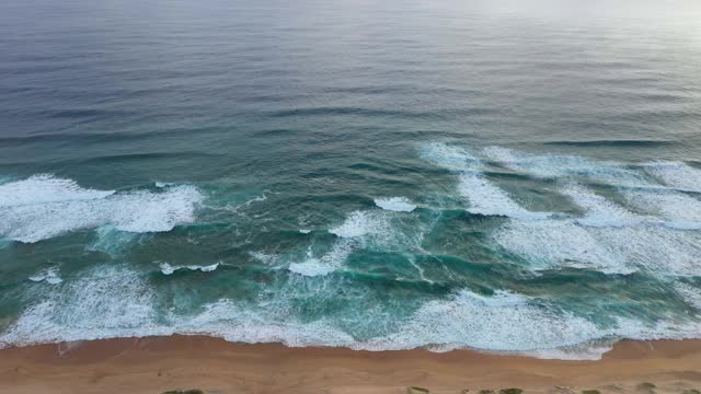 高角度的清澈的绿松石海和海浪沿海岸视频素材