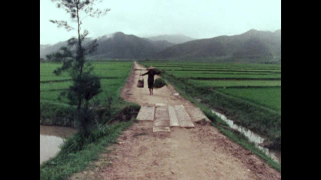 中国农村的妇女扛着沉重的担子;1973视频素材