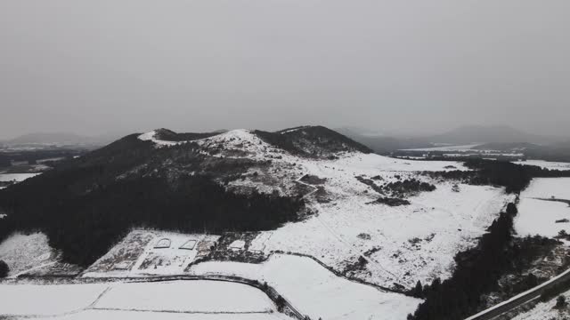 Oreum(寄生火山)和田野的雪景/济州岛，韩国视频素材