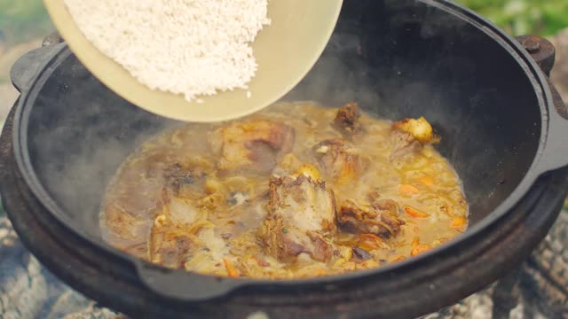 用肉，胡萝卜，大蒜和香料烹制传统的乌兹别克肉饭。在一个大平底锅里又漂亮又好吃。视频素材