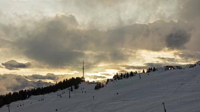 日落时，山上的云在跳舞。高山山坡全景。人们在瑞士阿尔卑斯山滑雪。Bettmeralp。广州Valais。视频素材