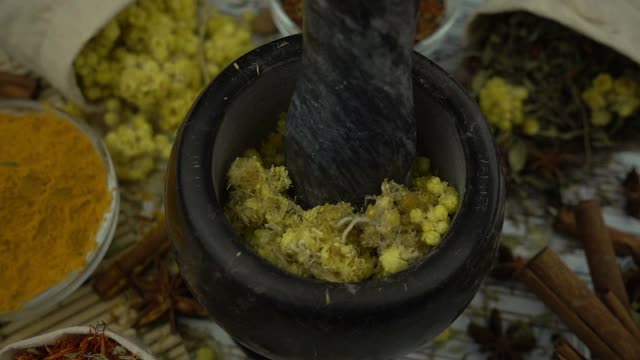 女人的手用花岗岩研钵和杵缓慢地混合和碾碎干花。健康有机食品、中草药、天然护理、芳香疗法和有机化妆品理念。视频素材