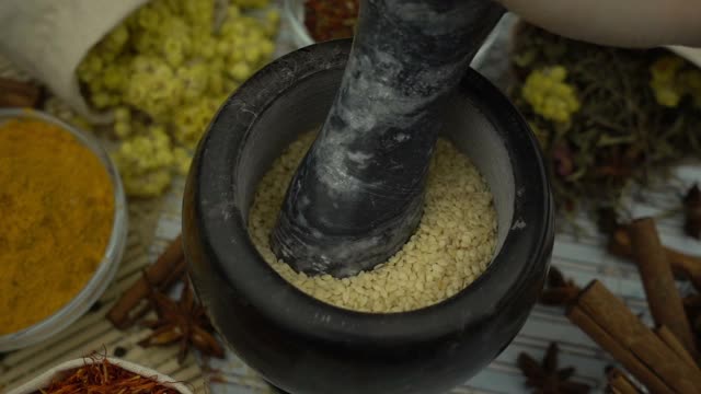 女人的手用花岗岩臼和杵慢慢混合和碾碎芝麻。健康有机食品、中草药、天然护理、芳香疗法和有机化妆品理念。视频素材