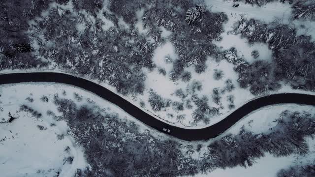 鸟瞰图的汽车行驶在乡村道路在下雪的冬天视频素材