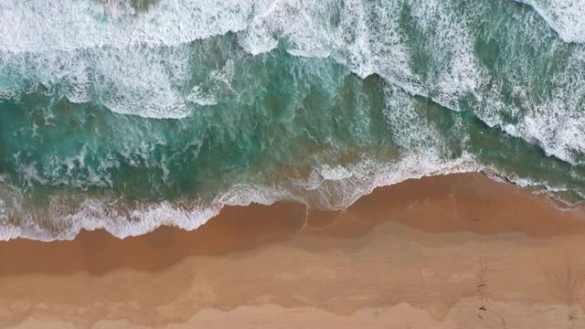 鸟瞰清澈的原始海洋和海浪沿海岸视频素材