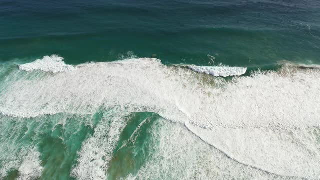 鸟瞰清澈的原始海洋和海浪沿海岸视频素材