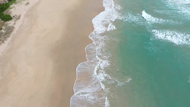 鸟瞰清澈的原始海洋和海浪沿海岸视频素材