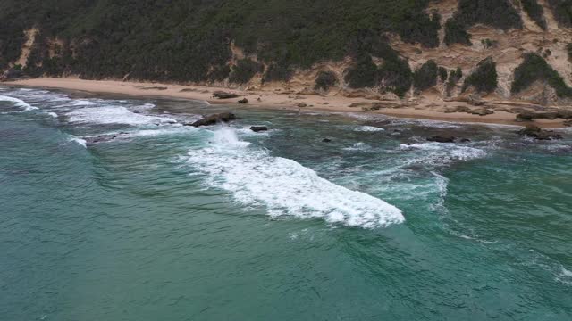 鸟瞰清澈的原始海洋和海浪沿海岸视频素材