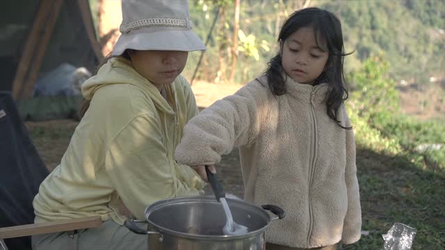 母亲和女儿花周末时间一起露营和做早餐视频素材