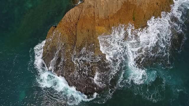 怀旧的航空视频，在缓慢的动作的海洋，波浪平稳地滚在岩石海岸的太平洋大西洋。视频素材