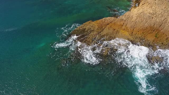 怀旧的航空视频，在缓慢的动作的海洋，波浪平稳地滚在岩石海岸的太平洋大西洋。视频素材