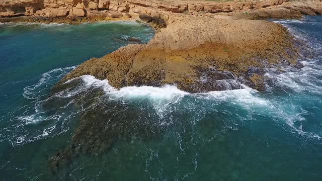 怀旧的航空视频，在缓慢的动作的海洋，波浪平稳地滚在岩石海岸的太平洋大西洋。视频素材