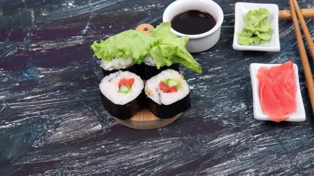 素食寿司卷，鳄梨，黄瓜沙拉和番茄黑色背景。健康素食的概念。视频素材