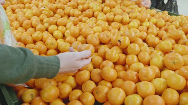 女人在店里挑选橘子视频素材